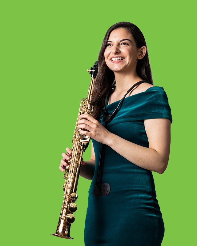 An RCM student playing the soprano saxophone against a green background